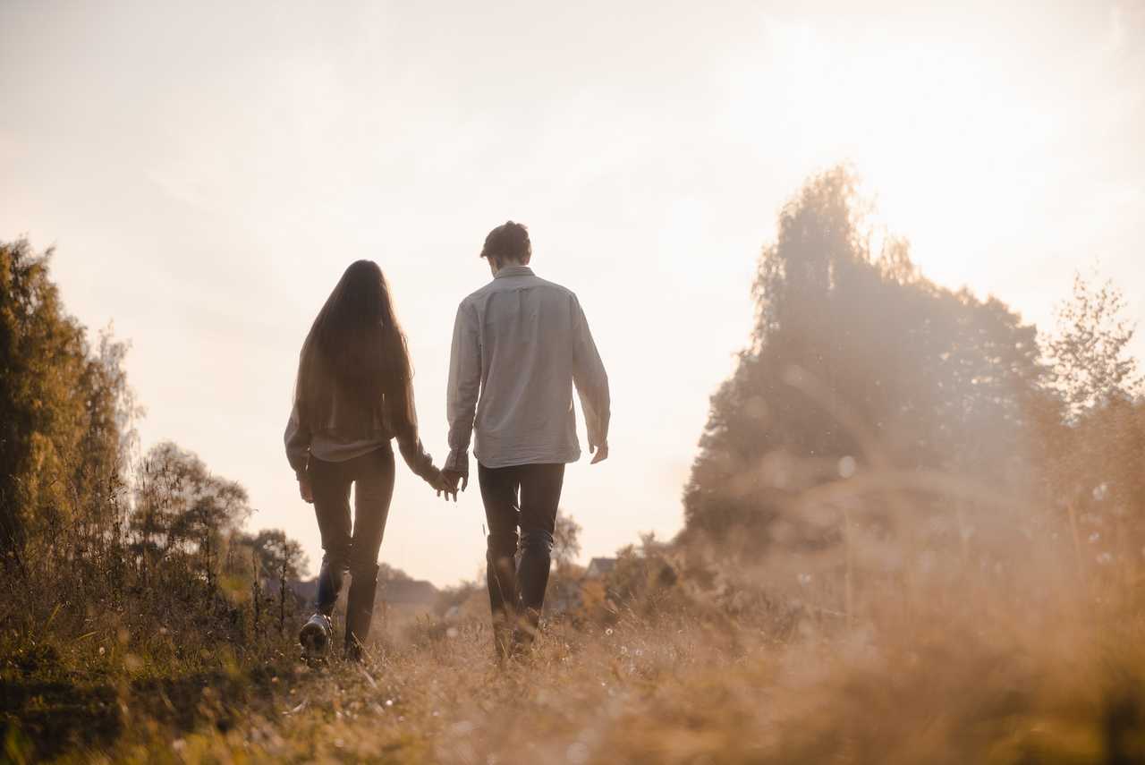 boyfriend and girlfriend walking in the woods hand in hand saying love messages for him